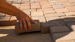 personne qui pose des pavés de terrasse